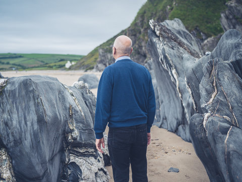 Senior man exploring rocky beach