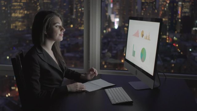 attractive sales women working on pc in modern city office at night