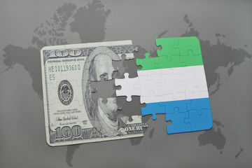 puzzle with the national flag of sierra leone and dollar banknote on a world map background.