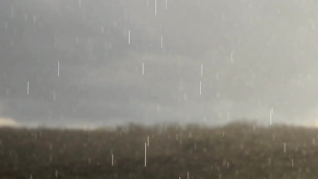 Lloviendo copiosamente en el cielo y en um prado
