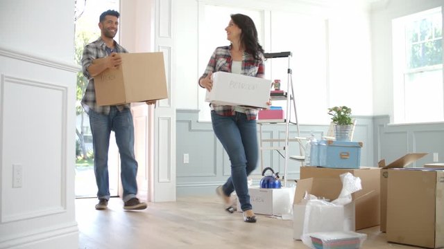 Slow Motion Shot Of Hispanic Family Moving Into New Home 