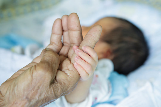 Close Up Baby Hands Holding Grandmother (Soft Focus And Blurry)