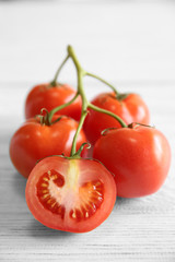 Bunch of red juicy tomatoes on light wooden background