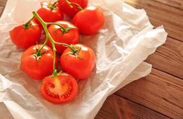 Bunch of red tomatoes in paper on wooden background