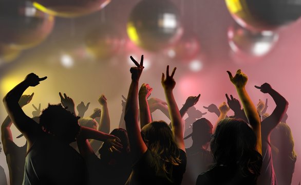 Nightlife and disco concept. Silhouettes of young people are dancing in club.