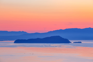 Fototapeta na wymiar sunset over the mountain with reflection on the sea