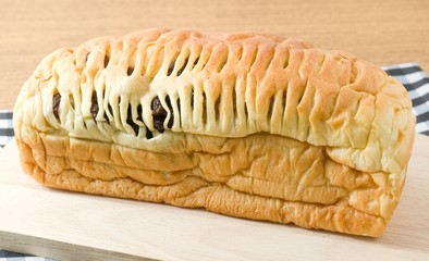 Cuisine and Food, Homemade Loaf of Brown Raisin Bread on Wooden Cutting Board.