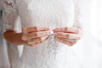 earring in bridal hands. Beautiful wedding accessories.  date. autumn holiday