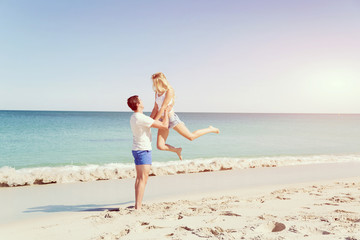 Fototapeta premium Happy couple jumping on beach vacations
