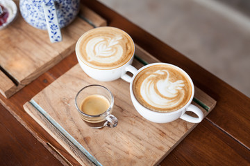 Cup of hot latte art coffee on wooden table