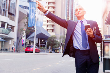 Businessman catching taxi in city