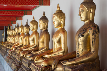 Gold Buddha Statue in Public Temple in Thailand. Row of Buddha imanges in different posture.
