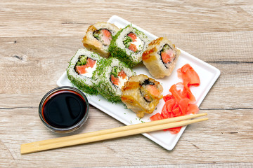 different rolls on a plate with ginger and soy sauce