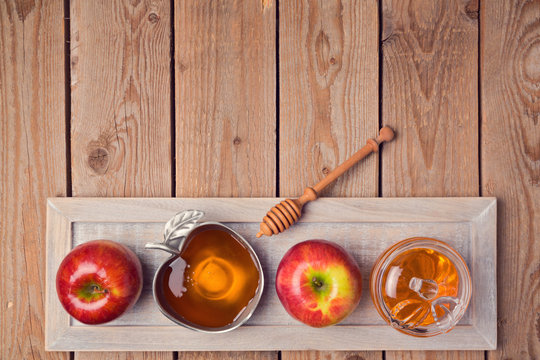 Jewish holiday Rosh Hashana background with honey and apples on wooden table. View from above. Flat lay