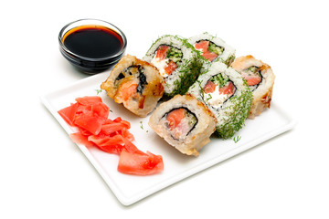 Japanese rolls on a plate with ginger and soy sauce.