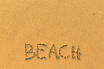 Beach - words hand-written on sand beach.