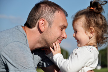 Happy father with his daughter outdoors hugging together