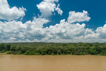 nature of clouds and blue sky and forest and river in a clear day