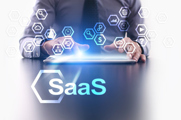 Businessman is using tablet pc and selecting SaaS icon.