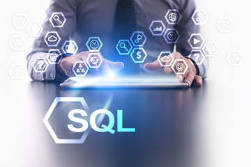 Businessman is using tablet pc and selecting SQL icon.