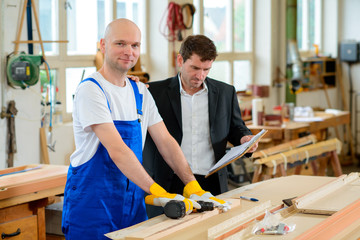 boss and worker in a carpenter's workshop