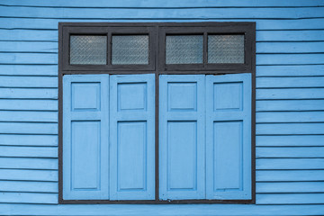 Blue windows on old wooden wall