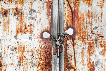 Vintage rusty gate with locked master key and chain