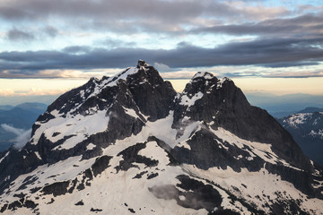 Aerial Landscape of the beautiful mountain peaks in British Columbia, Canada. Taken on a cloudy sunset near Vancouver.