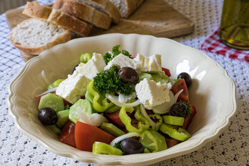 Traditional greek salad, served with bread on table
