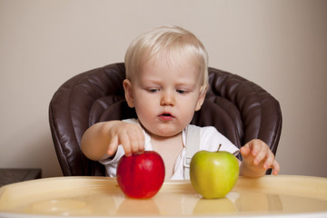 Fototapeta premium Two year baby boy sitting at the dinner table