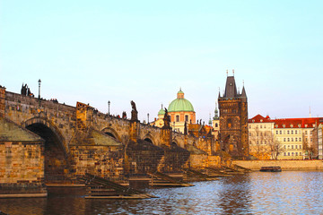 Fototapeta premium Sun setting over Charles Bridge and Vltava river in Prague