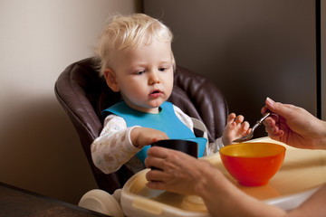 Two year baby boy sitting at the dinner table