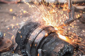 Worker cutting steel using metal torch