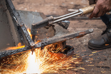 Worker cutting steel using metal torch