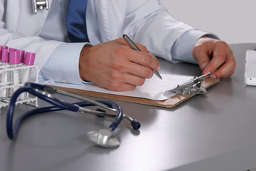 Male doctor write on the desk with test tube