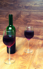 Wine glass and bottle on a wooden background
