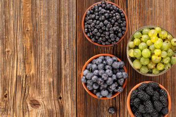 Fresh blueberries and blackberries on old wooden background