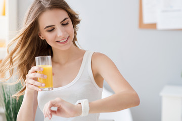 Positive woman drinking orange juice.
