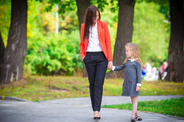 Obraz premium Mother brings her daughter to school. Adorable little girl feeling very excited about going back to school