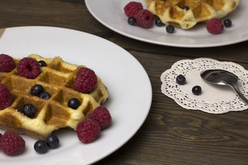 two plates of waffles with berries
