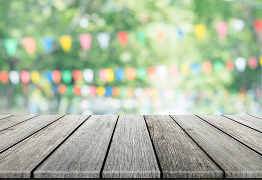 Empty wooden table with party in garden background blurred.