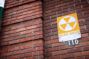 vintage fallout shelter sign on old brick building