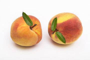 Two peach fruits with leaf isolated on white background