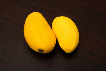 Fresh ripe chaunsa mangoes on dark wooden background