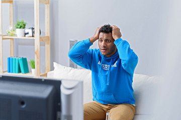 Young attractive african man watching television