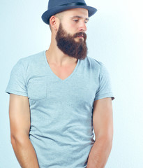 Obraz premium Portrait of handsome bearded man in hat standing with bag, isolated on white background