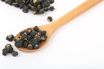 Traditional Chinese  black herbs dried wolfberry close up on a small spoon