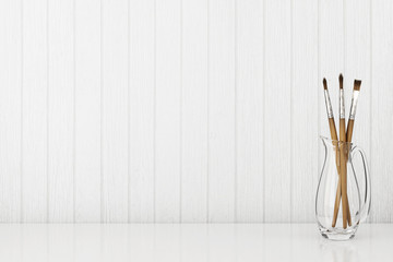 Interior background with art brushes in glass jug on empty white wooden wall. 3D rendering.