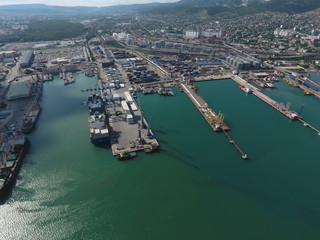 Obraz premium Industrial seaport, top view. Port cranes and cargo ships and barges.