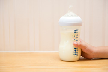 kid getting a baby bottle of powdered milk without lid at home
